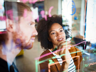Consulting team discussing project plans at the whiteboard.